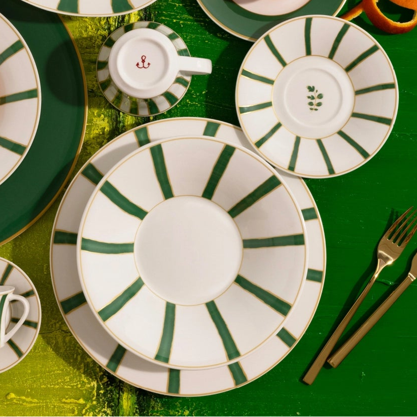 Set of green and white ceramic plates and tableware on a green background