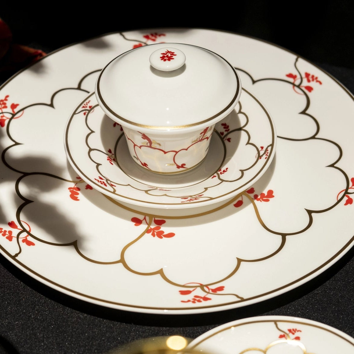 Ceramic teacup and saucer set on a decorative plate with floral patterns