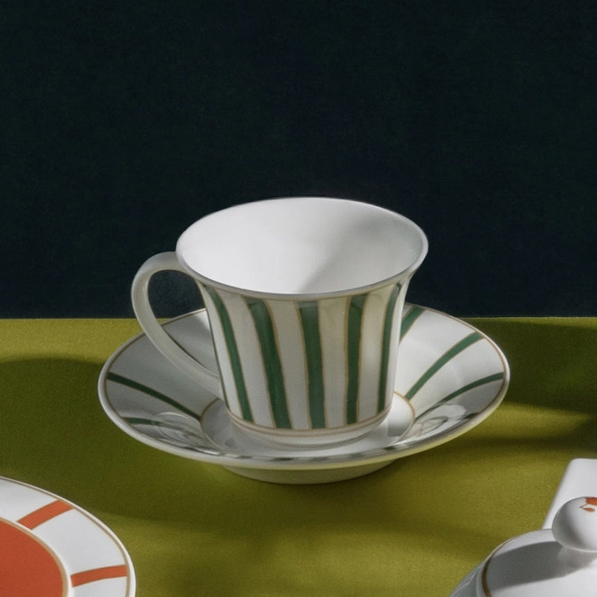Ceramic tableware set on a green surface with a dark background