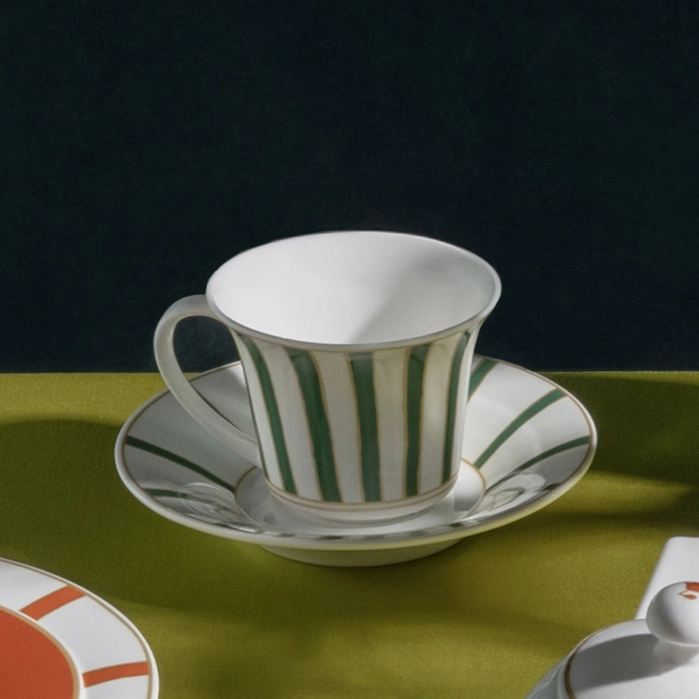 Ceramic tableware set on a green surface with a dark background