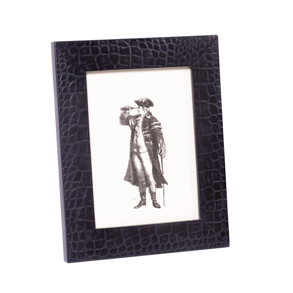 Black crocodile-patterned frame with a black and white print of a person in a coat and hat.