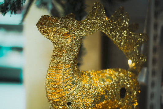 A golden glitter reindeer decoration with antlers.