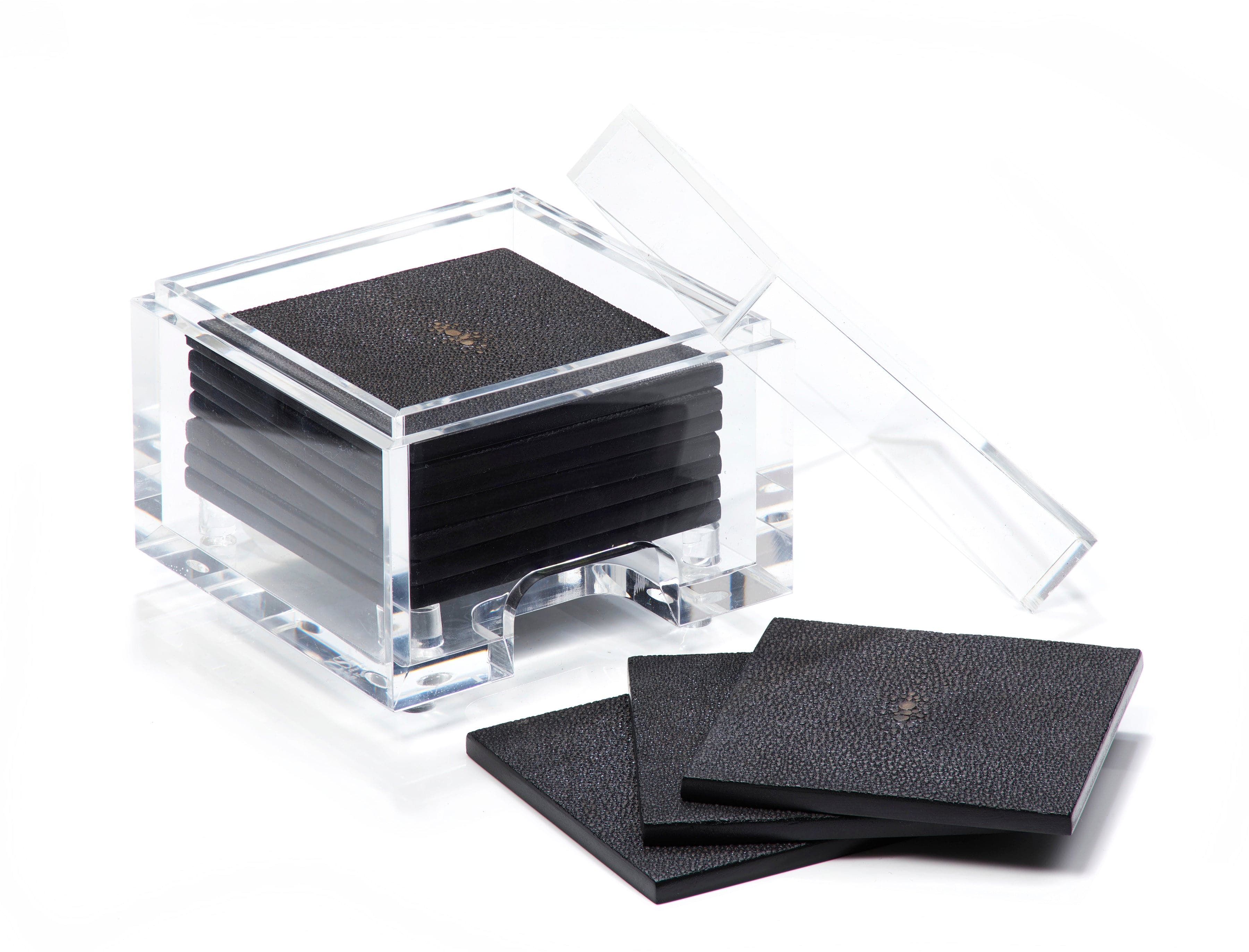 Set of black coasters with a clear acrylic holder on a white background