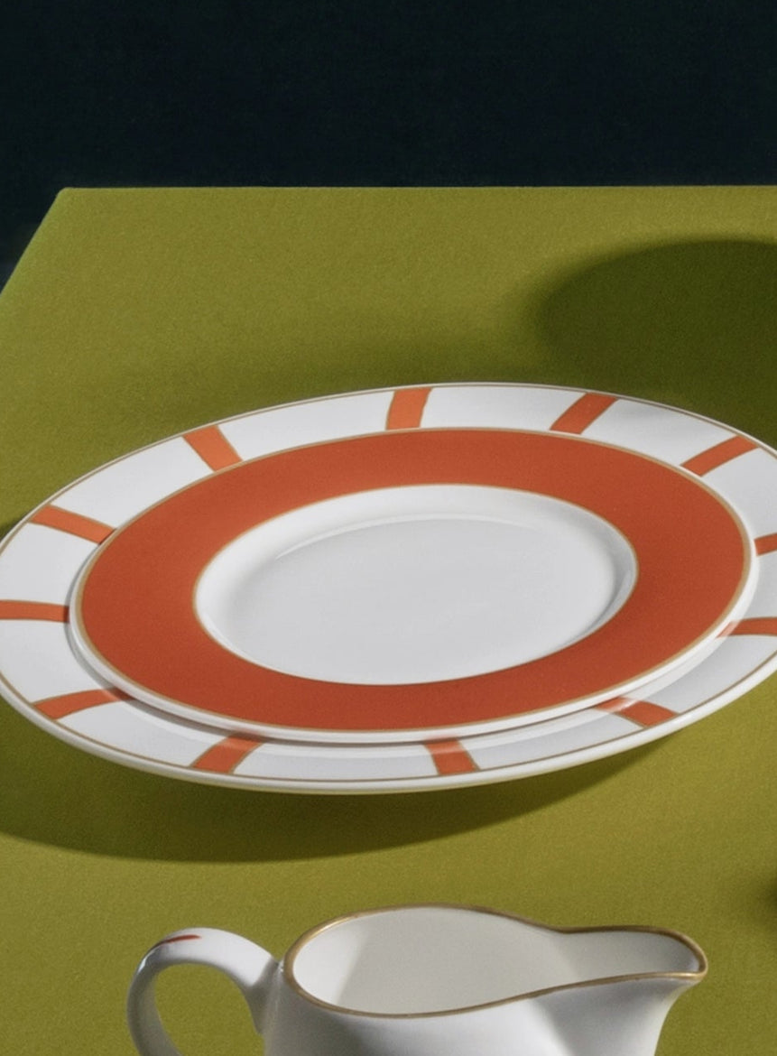 Ceramic tableware set on a green surface with a dark background