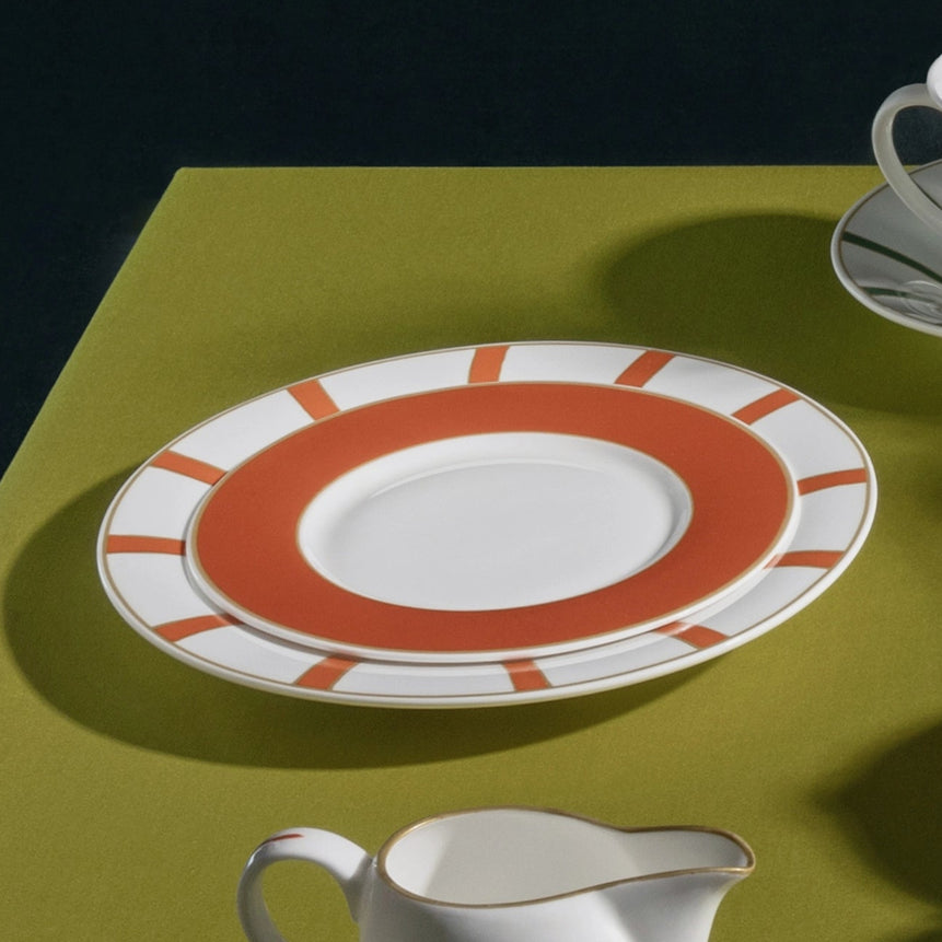 Ceramic tableware set on a green surface with a dark background